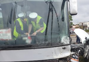 Zdjęcie pokazuje policjantów podczas czynności w sprawie wypadku z udziałem autobusu i pojazdu osobowego
