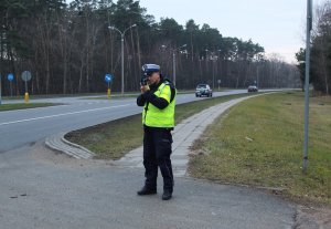policjant korzystający z ręcznego miernika prędkości
