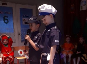 chłopcy w strojach policjantów, biorący udział w przedstawieniu