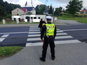 Policjant RD monitoruje przejście, po którym przechodzi rowerzystka