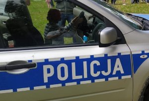 Policjanci podczas pikniku prezentują sprzęt dzieciom