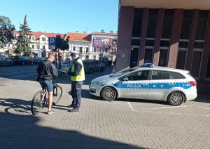 Policjant ruchu drogowego podczas rozmowy z rowerzystą jako jednym z uczestników ruchu drogowego